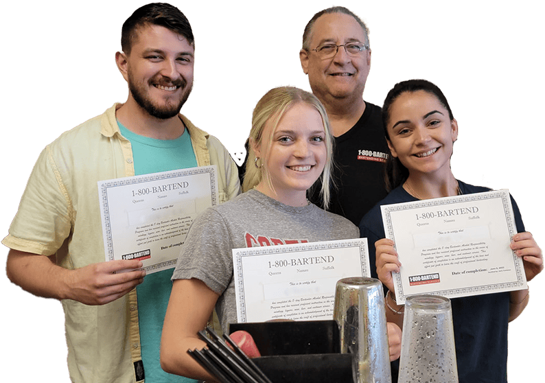 Four people smiling and holding bartending certificates from the New York Bartending School. They are gathered around a bar area with various bartending tools and ingredients, celebrating their newfound skills.