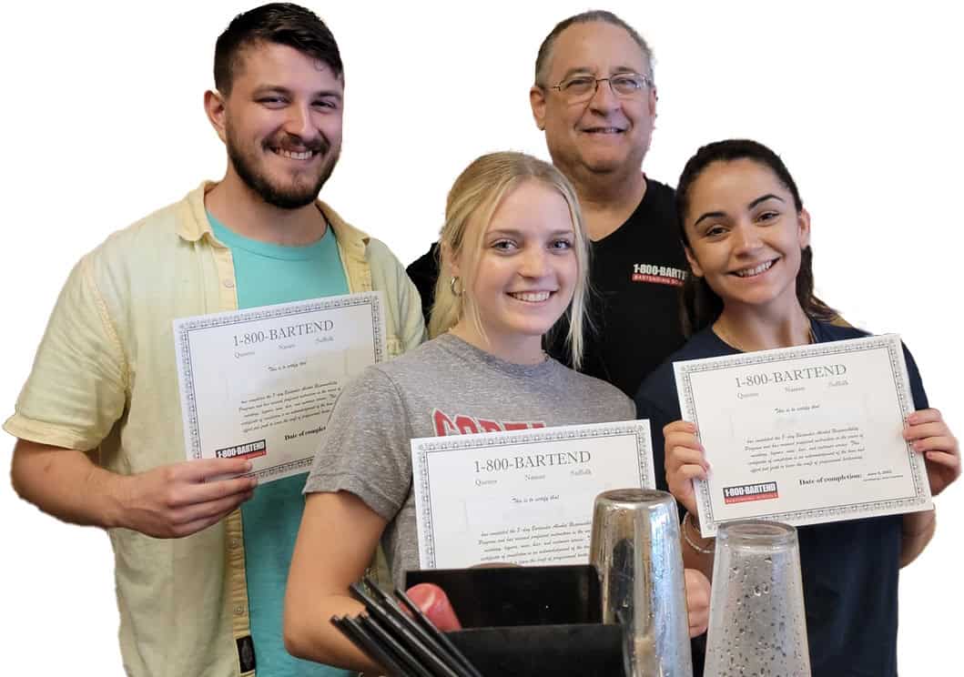 Four people smiling and holding certificates while standing behind a bar counter with bartending tools. They are celebrating their achievement at the New York Bartending School.